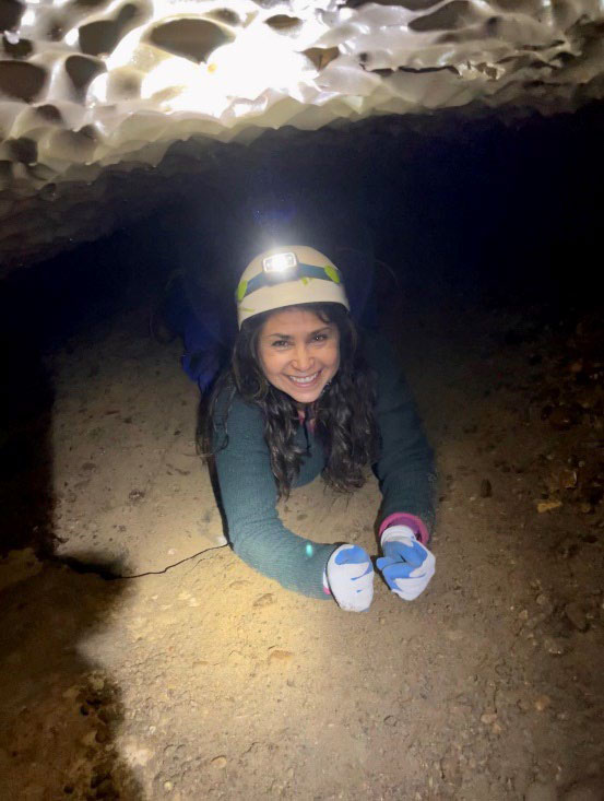 A photograph of Jacelyn Downey, crawling through a cave. 
